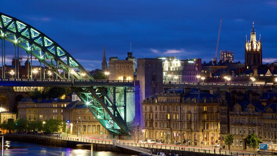A cityscape with a prominent green-lit bridge, historic buildings, and a tall church spire.