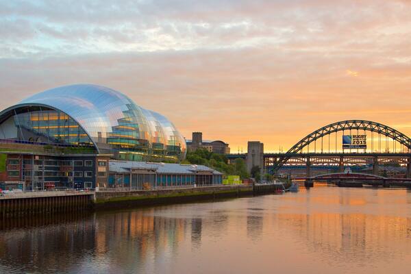 A modern stadium with a glass dome, a river, and a bridge with a sign for the Rugby World Cup 2015.