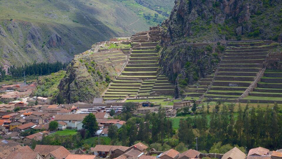 Terraced agricultural fields, a village with traditional architecture, and a mountainous backdrop.
