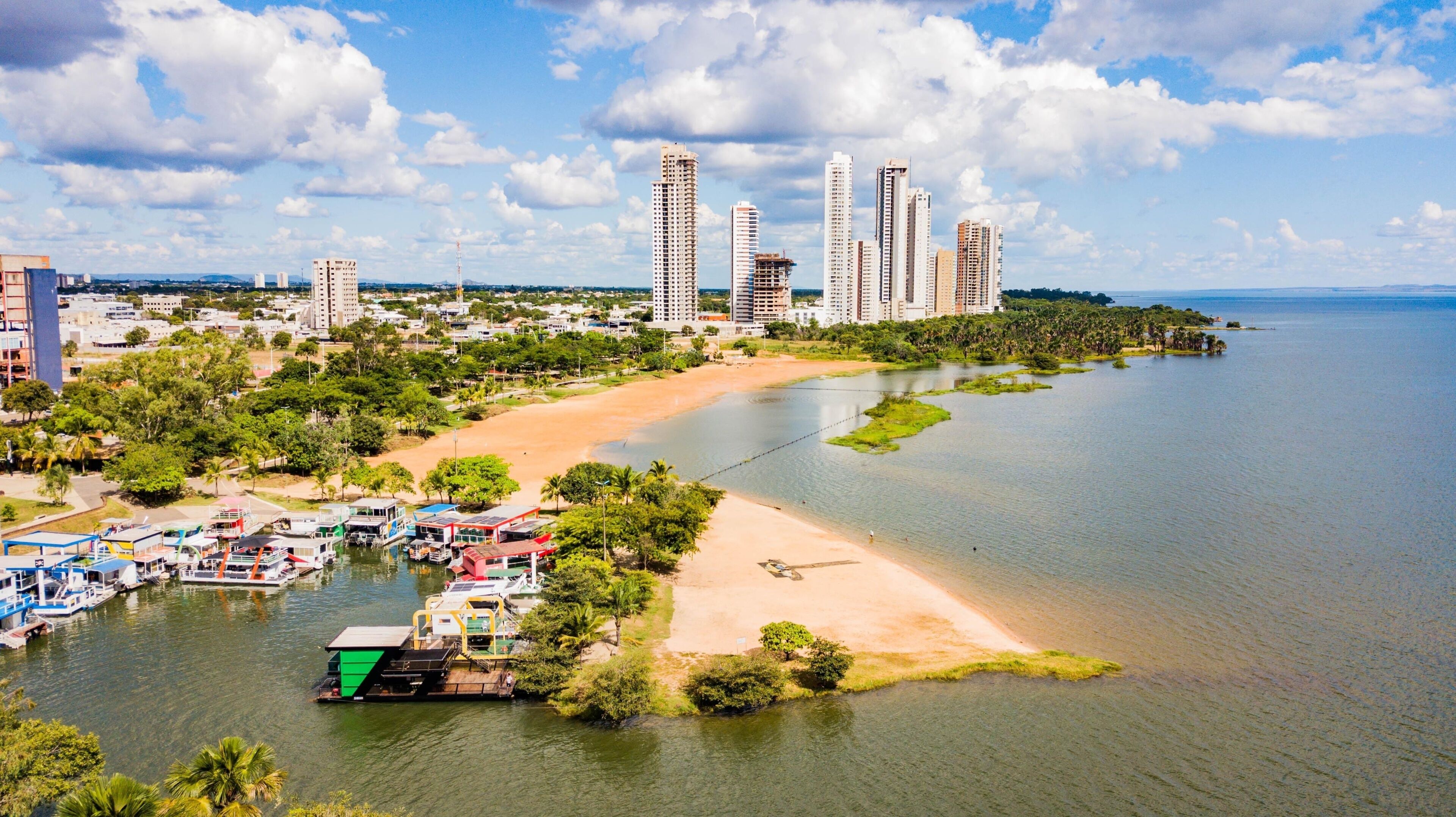 A coastal cityscape with a river, beach, and high-rise buildings.