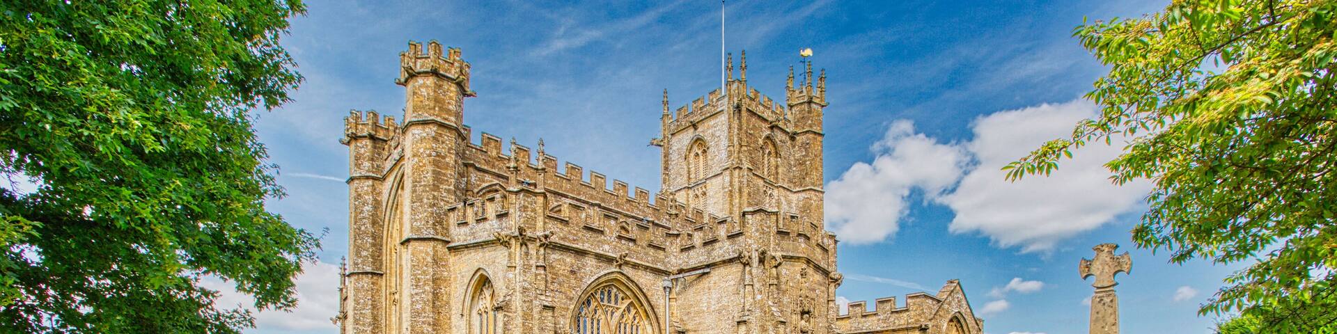 A historic church with a large arched window and a tall tower.