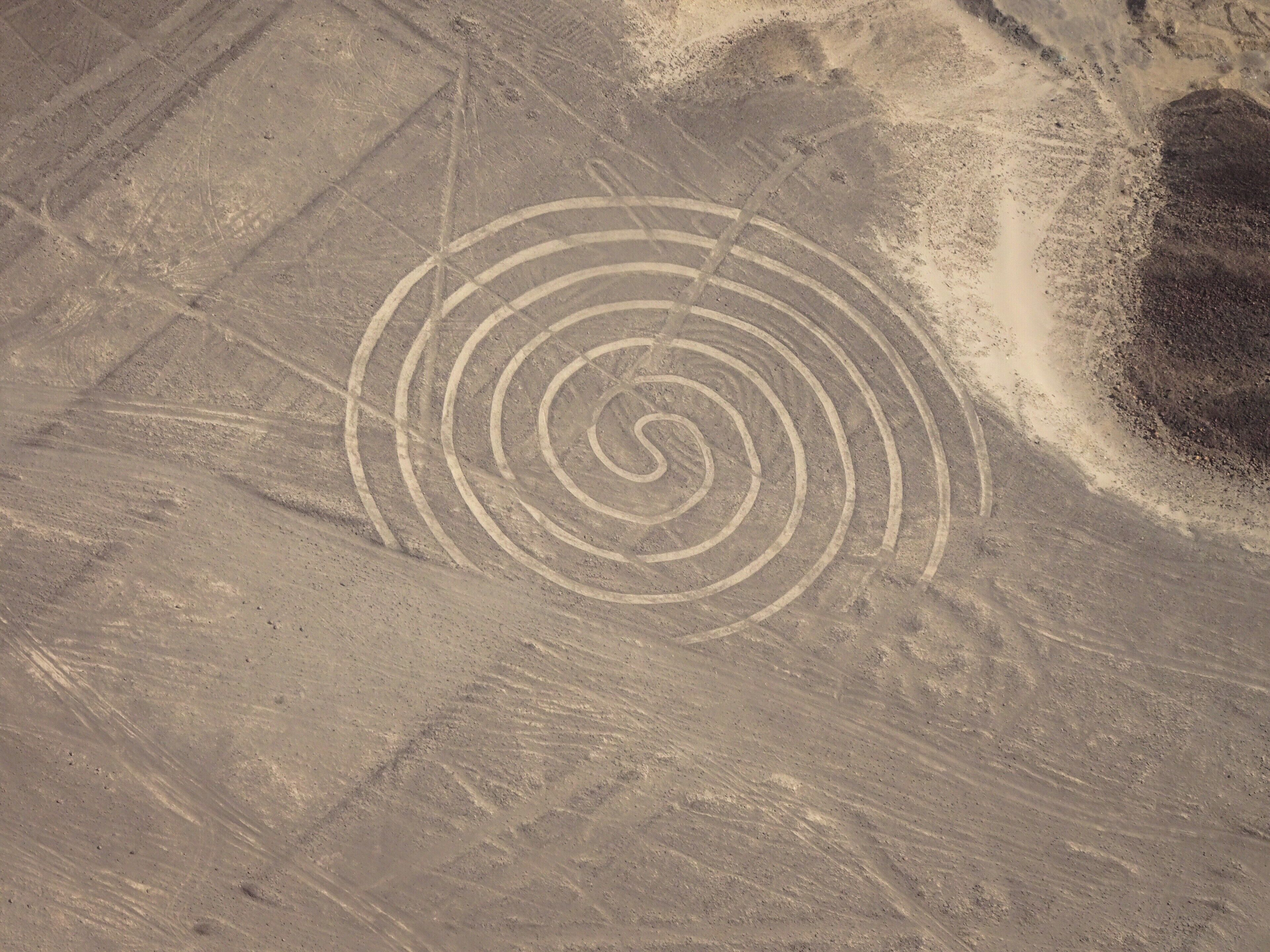 A desert landscape with a spiral pattern etched into the ground.