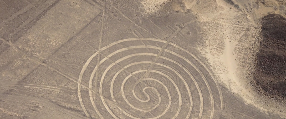 A desert landscape with a spiral pattern etched into the ground.