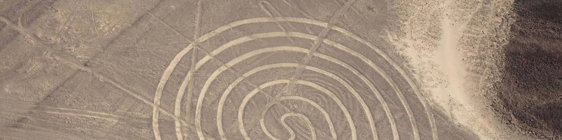 A desert landscape with a spiral pattern etched into the ground.