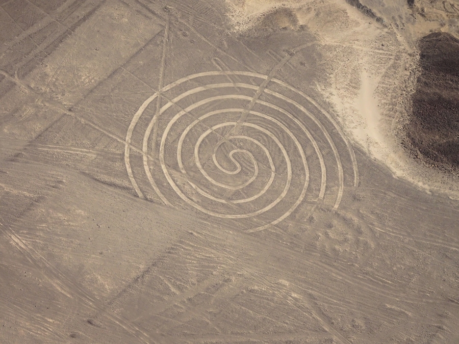 A desert landscape with a spiral pattern etched into the ground.