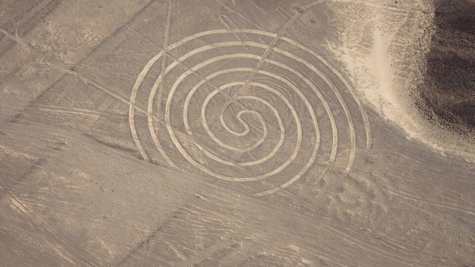 A desert landscape with a spiral pattern etched into the ground.