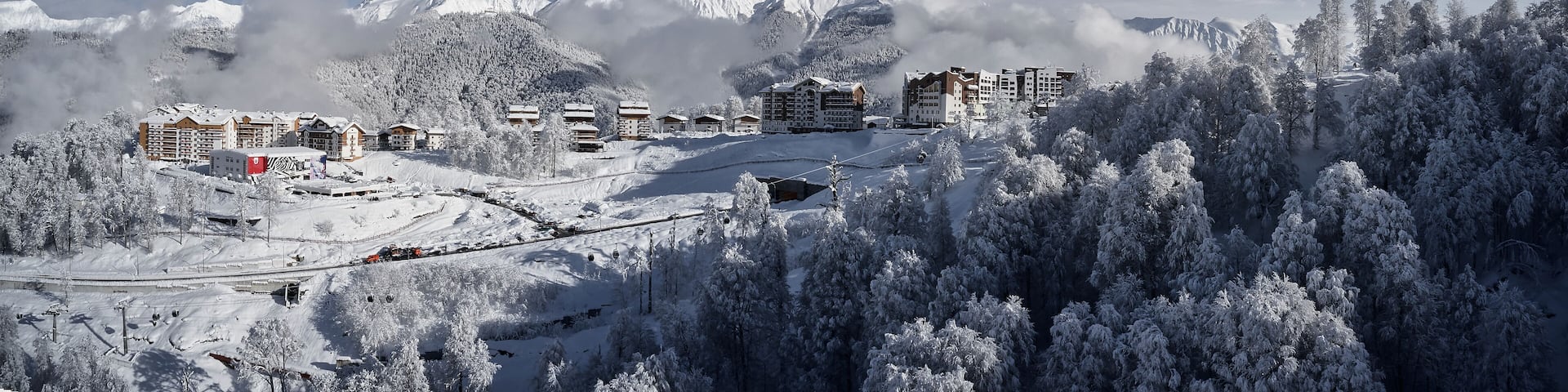 Panoramic view of the mountains and the village of Krasnaya Polyana. Aerial photography with copter. Esto-Sadok. Sochi. ski resort. Nature, snow, skiing, snowboarding