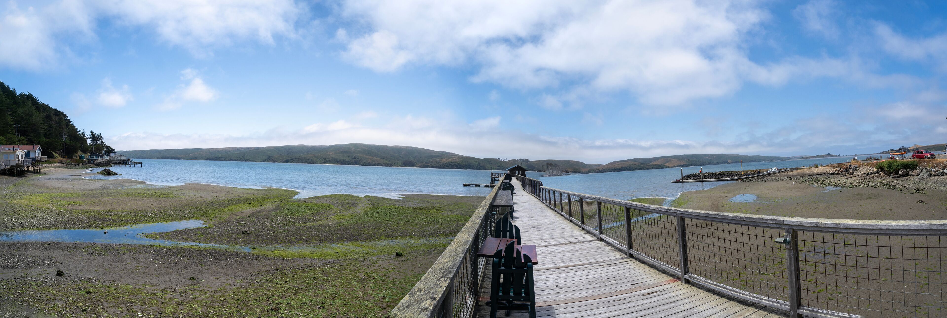 A wooden boardwalk leading to a lake with a clear sky.