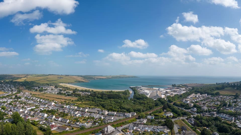 A coastal town with a beach, railway, and industrial buildings.