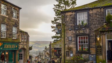 Rua de calçada adornada por edifícios históricos, incluindo um pub chamado Black Bull.