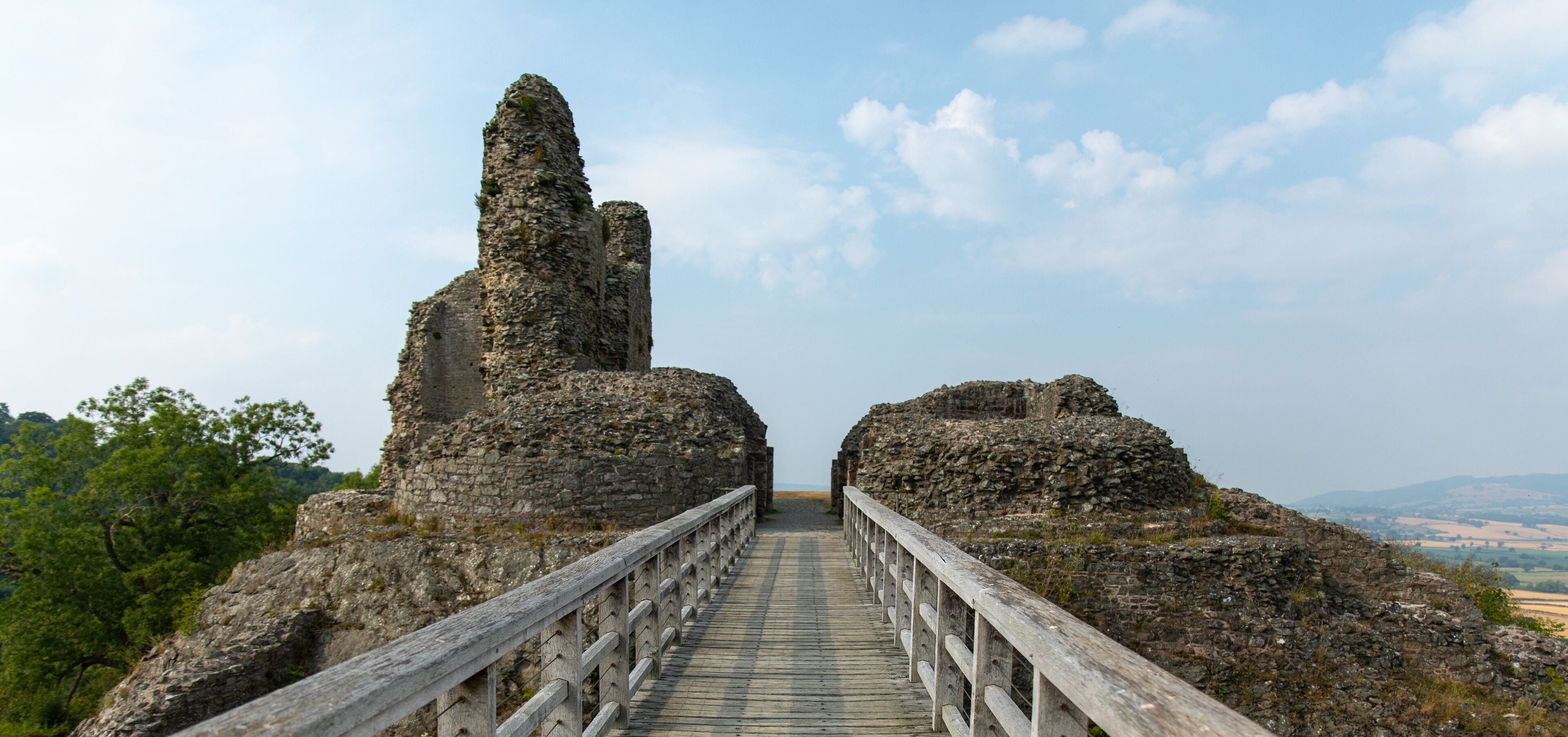 View of Montgomery Castle and bridge in mid-Wales in UK against a blue sunny sky