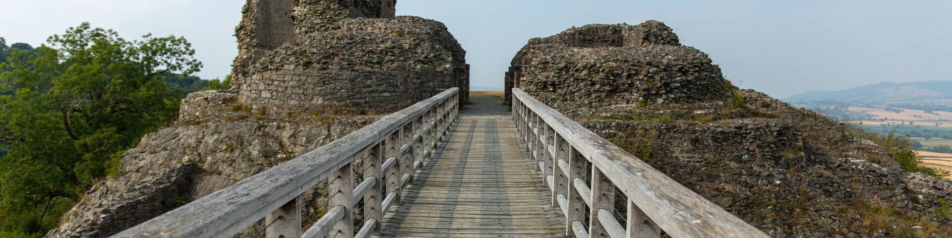 View of Montgomery Castle and bridge in mid-Wales in UK against a blue sunny sky