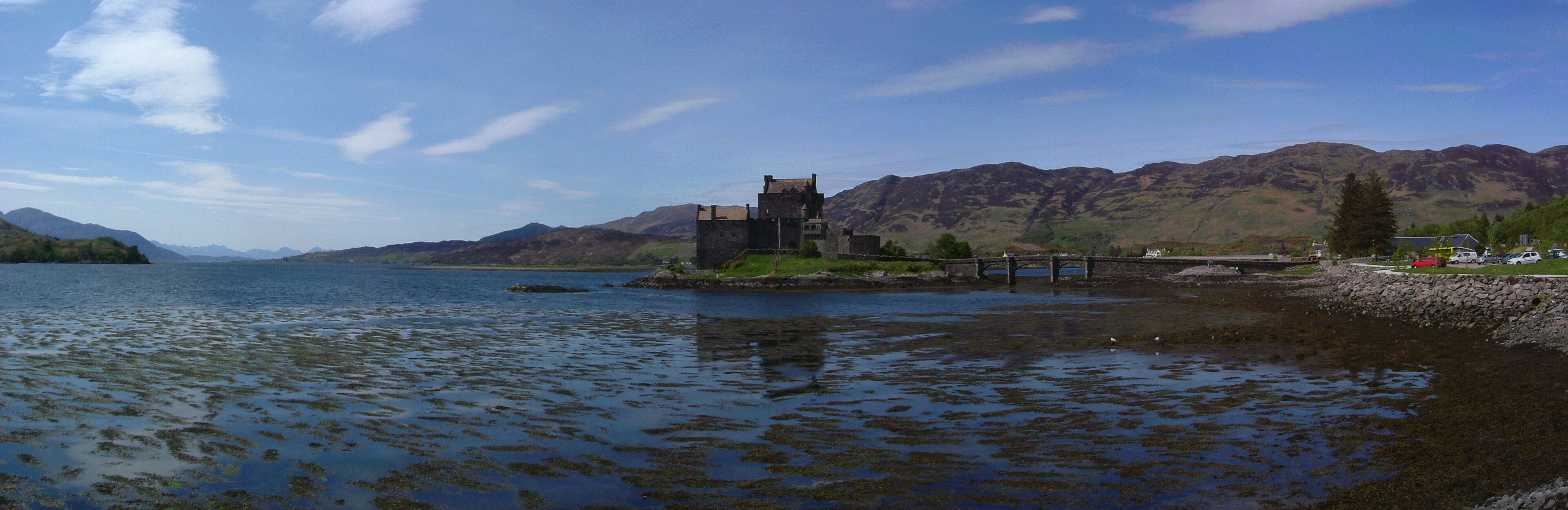 Eilean Donan Castle in Loch Duich, with the Isle of Skye visible in the distance. three photos stitched together using hugin, nona and enblend.