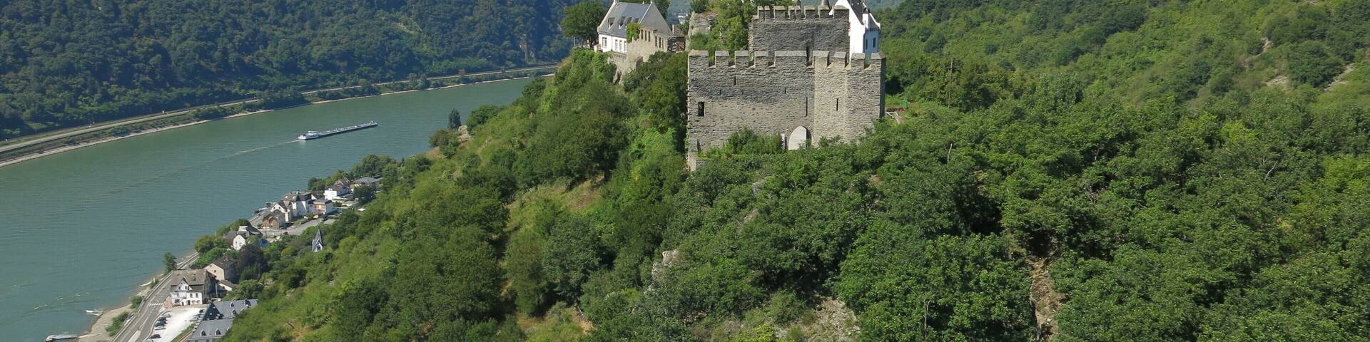 A castle on a hill overlooking a river.