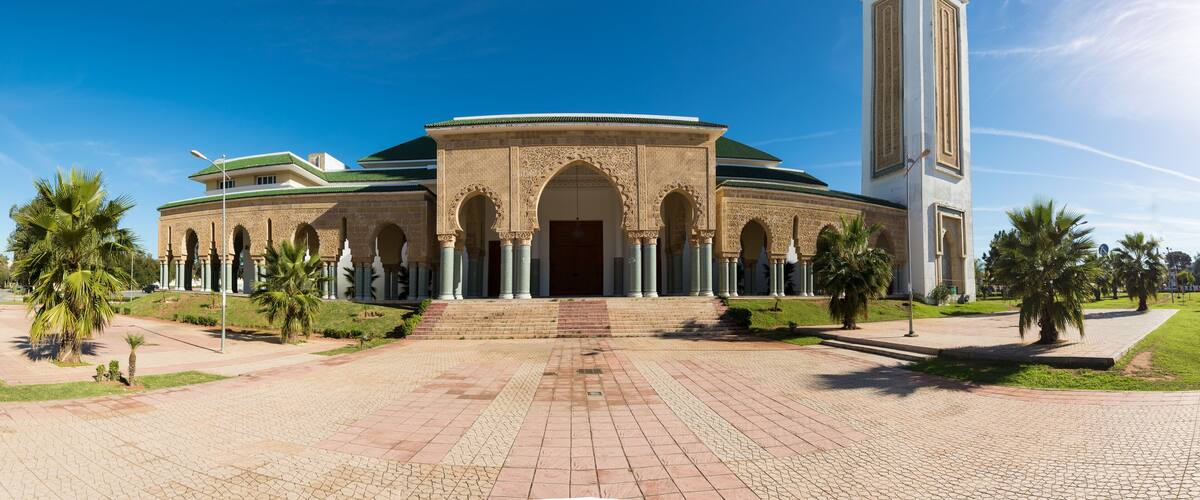 A historic building with arches and a tall tower.