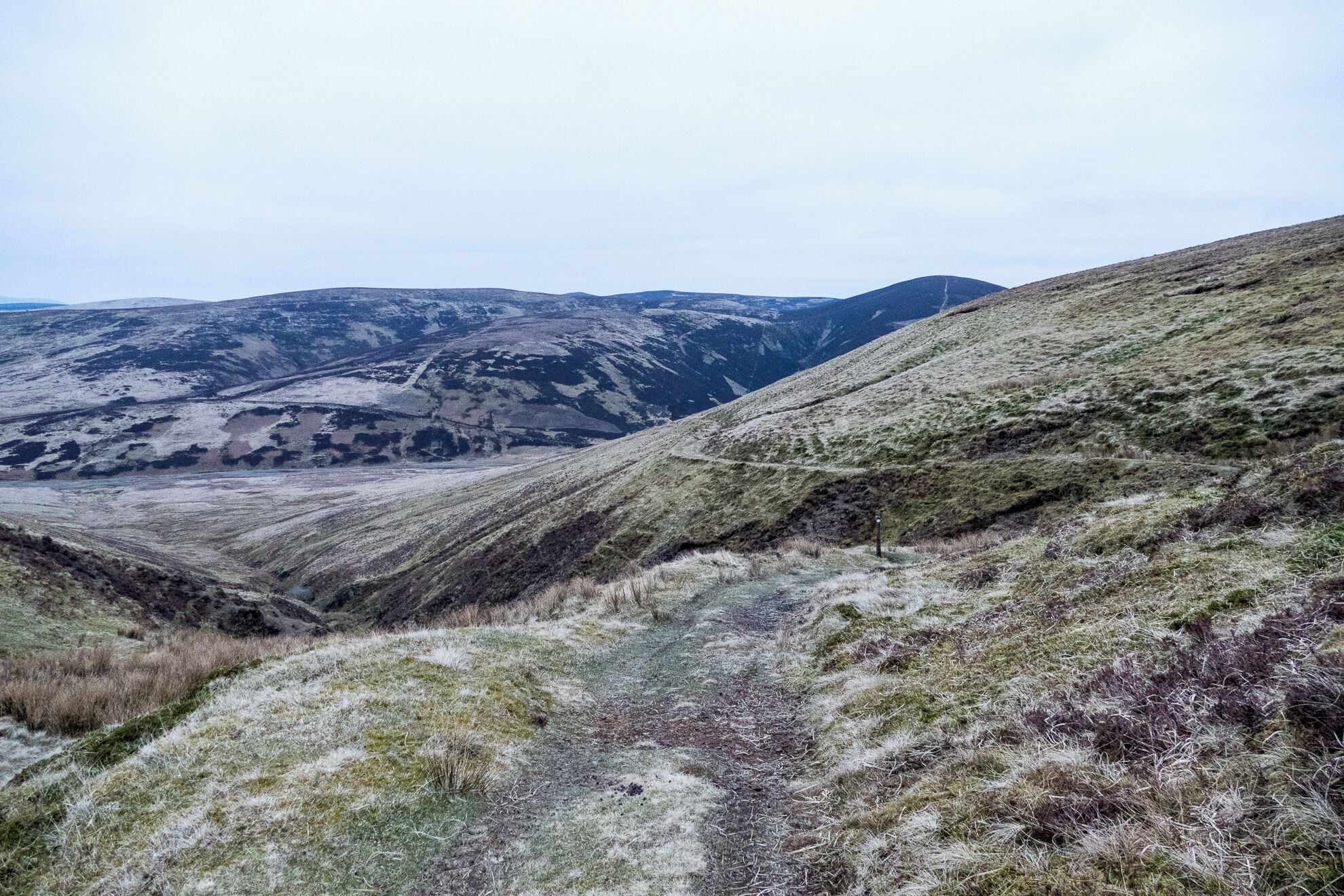 Un paisaje montañoso con un sendero y colinas distantes.