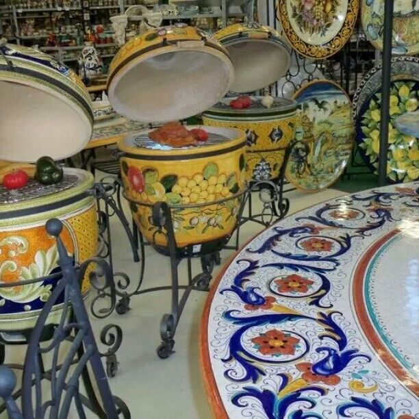Una exhibición de ollas y sartenes de cerámica coloridas con diseños elaborados.