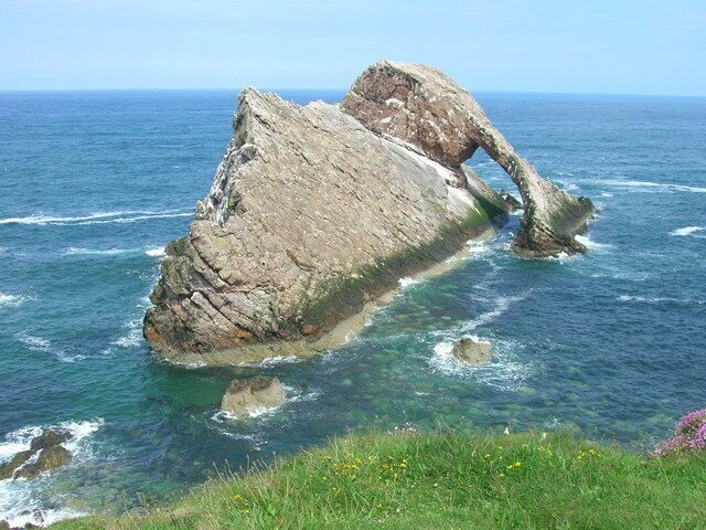 A large rock formation extending into the sea.