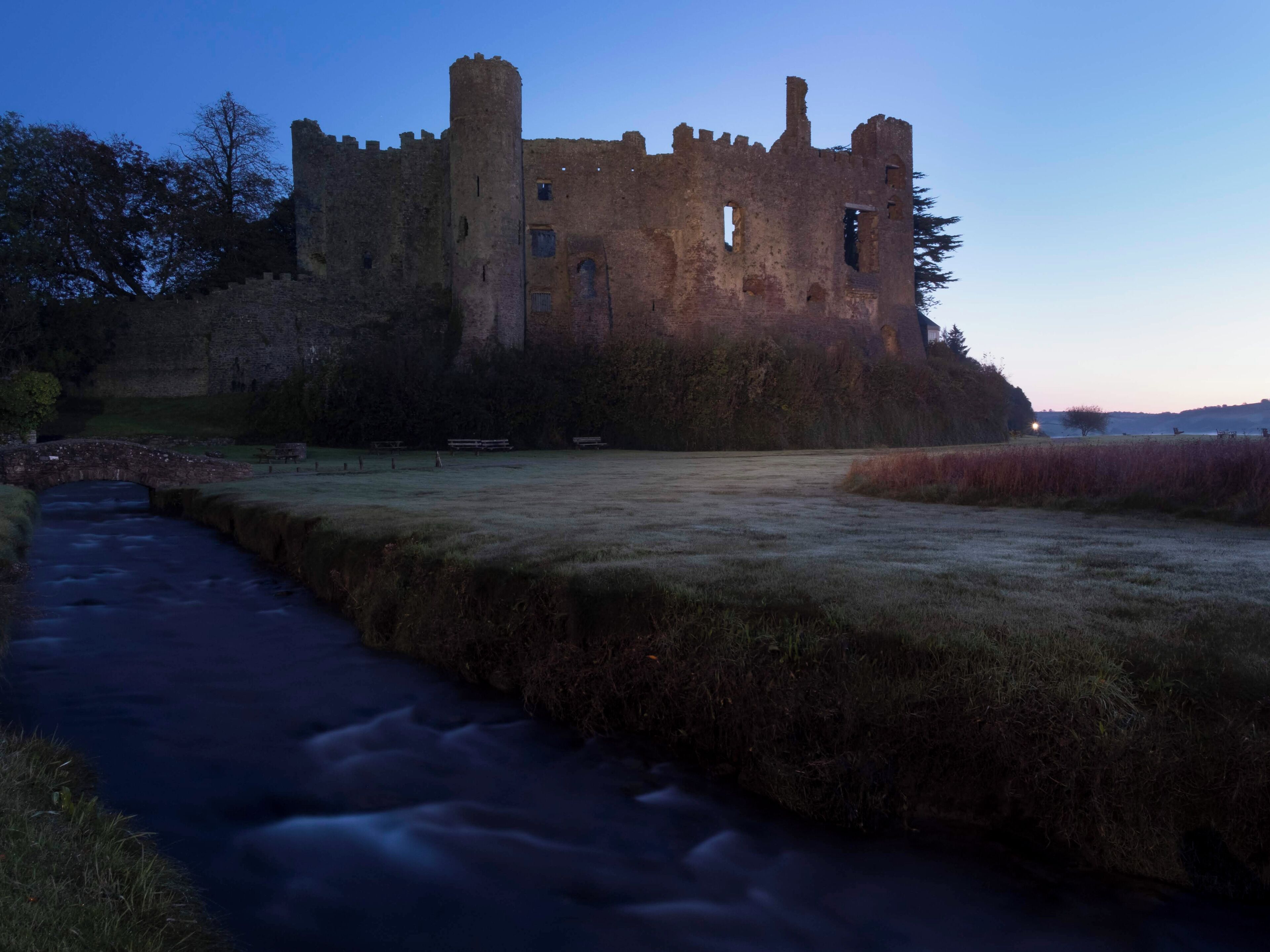 Laugharne castle just at the end of the blue hour on a cool early morning.