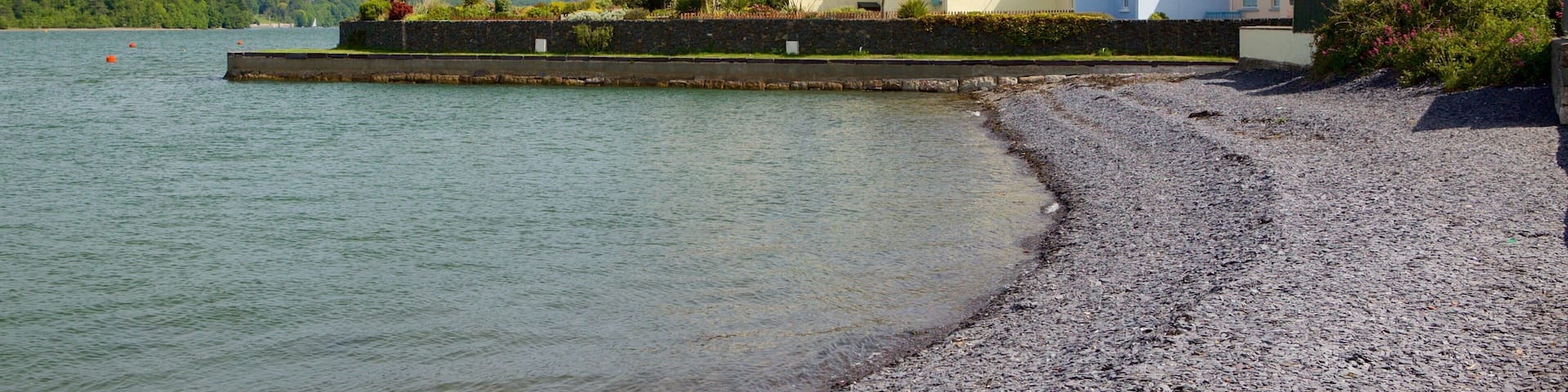 Y Felinheli mit einem Kleinstadt oder Dorf und Steinstrand