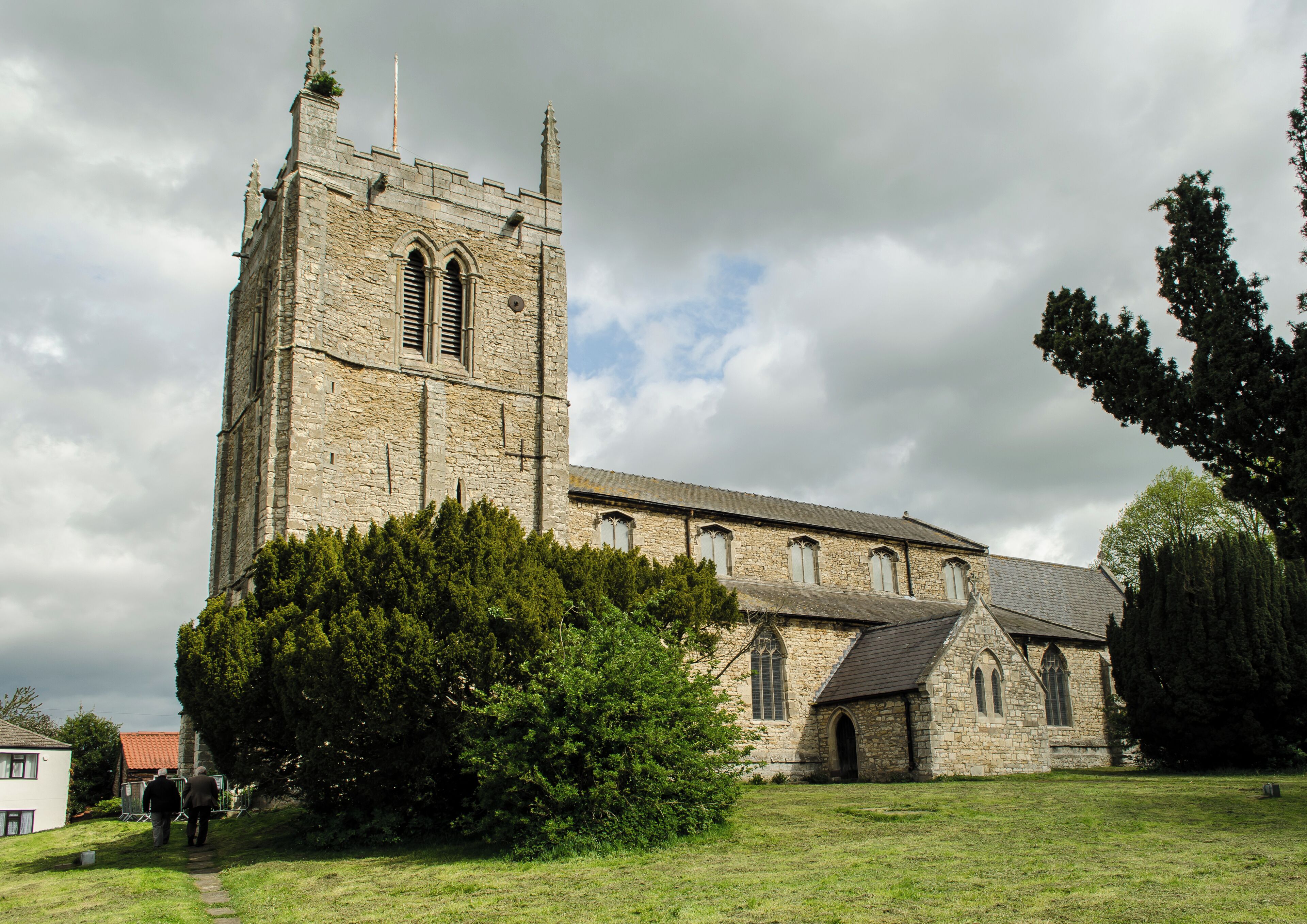 Grade I listed The church is built on the site of a Saxon place of worship, of which little remains. The name Kirton means "town of the church". Around the year 1200 the original church was demolished and enlarged and rebuilt. There is a priests door in the south wall with a pre-Norman tympanum, probably the oldest part of the church. There is a west tower, five bay nave with north and south aisles and clerestory, north and south porches, three bay chancel and vestry. The massive three stage west tower dates from the 13th century, and has a 15th century battlemented parapet with crocketted finials. Inside the tower the ringing chamber has a painted ceiling. The pillars of the north arcade (late 12th century) are set on larger bases which could have formed the wall of an earlier church. The south arcade is later (late 13th century) and the carving style of the capitals is inferior. The nave clerestory was added in the 15th century, at the same time the tower was strengthened, and in 1553 three bells were installed in the tower. There are now eight bells. The chancel was rebuilt in 1860 by Ewan Christian, the chancel arch dates from that time. The nave floor is higher than the floor of the tower, and it is believed that 375 people are interred within the church. The western Gallery was also removed in 1860, and the north porch was built. There is an effigy of a Knight, possibly Sir Gilbert Waterhouse who served with Henry III. The effigy is defaced, and dates from the mid-13th century. He lies with crossed legs and raised hands. The effigy was buried in the 17th century and later dug up. The organ dates from 1874 and was built by Walker & Sons. There are several commemorative stained-glass windows, the east window is by Clayton and Bell.