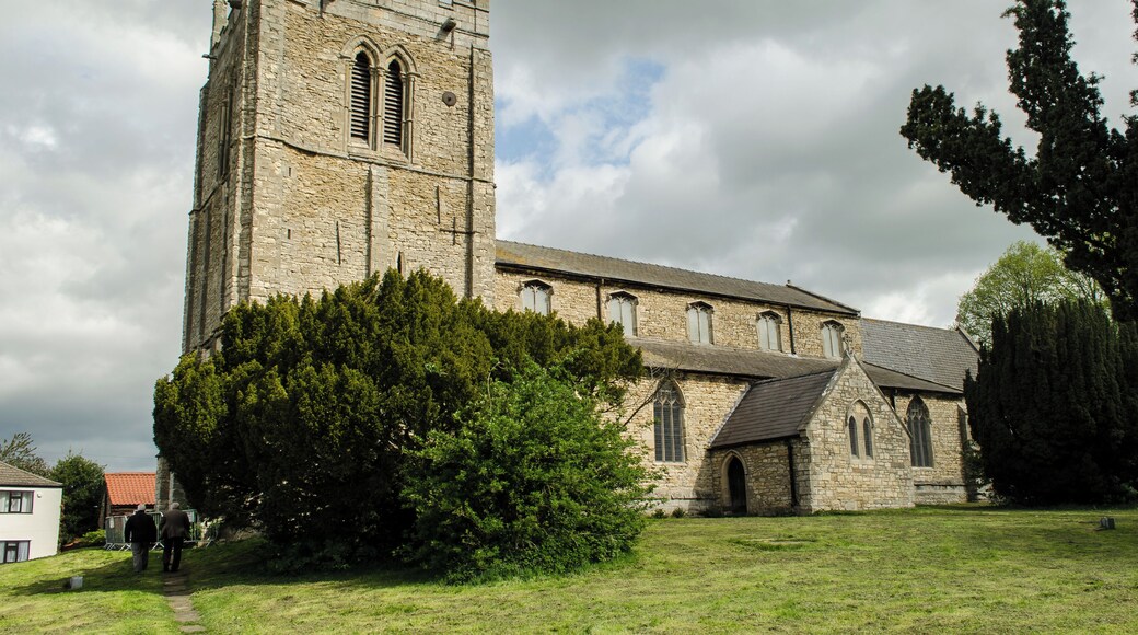 Grade I listed The church is built on the site of a Saxon place of worship, of which little remains. The name Kirton means "town of the church". Around the year 1200 the original church was demolished and enlarged and rebuilt. There is a priests door in the south wall with a pre-Norman tympanum, probably the oldest part of the church. There is a west tower, five bay nave with north and south aisles and clerestory, north and south porches, three bay chancel and vestry. The massive three stage west tower dates from the 13th century, and has a 15th century battlemented parapet with crocketted finials. Inside the tower the ringing chamber has a painted ceiling. The pillars of the north arcade (late 12th century) are set on larger bases which could have formed the wall of an earlier church. The south arcade is later (late 13th century) and the carving style of the capitals is inferior. The nave clerestory was added in the 15th century, at the same time the tower was strengthened, and in 1553 three bells were installed in the tower. There are now eight bells. The chancel was rebuilt in 1860 by Ewan Christian, the chancel arch dates from that time. The nave floor is higher than the floor of the tower, and it is believed that 375 people are interred within the church. The western Gallery was also removed in 1860, and the north porch was built. There is an effigy of a Knight, possibly Sir Gilbert Waterhouse who served with Henry III. The effigy is defaced, and dates from the mid-13th century. He lies with crossed legs and raised hands. The effigy was buried in the 17th century and later dug up. The organ dates from 1874 and was built by Walker & Sons. There are several commemorative stained-glass windows, the east window is by Clayton and Bell.
