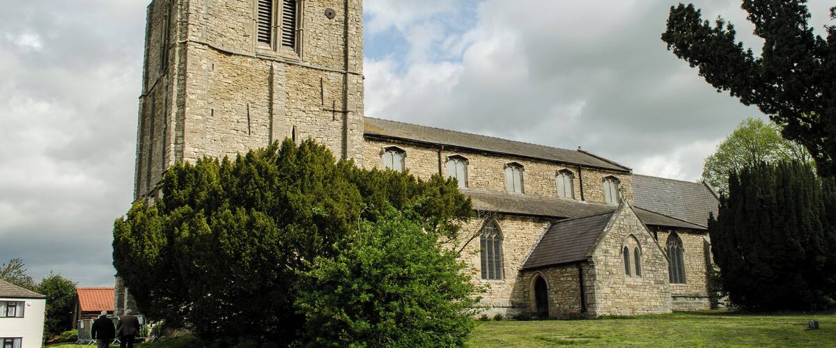 A historic church with a tall tower and a smaller attached building.
