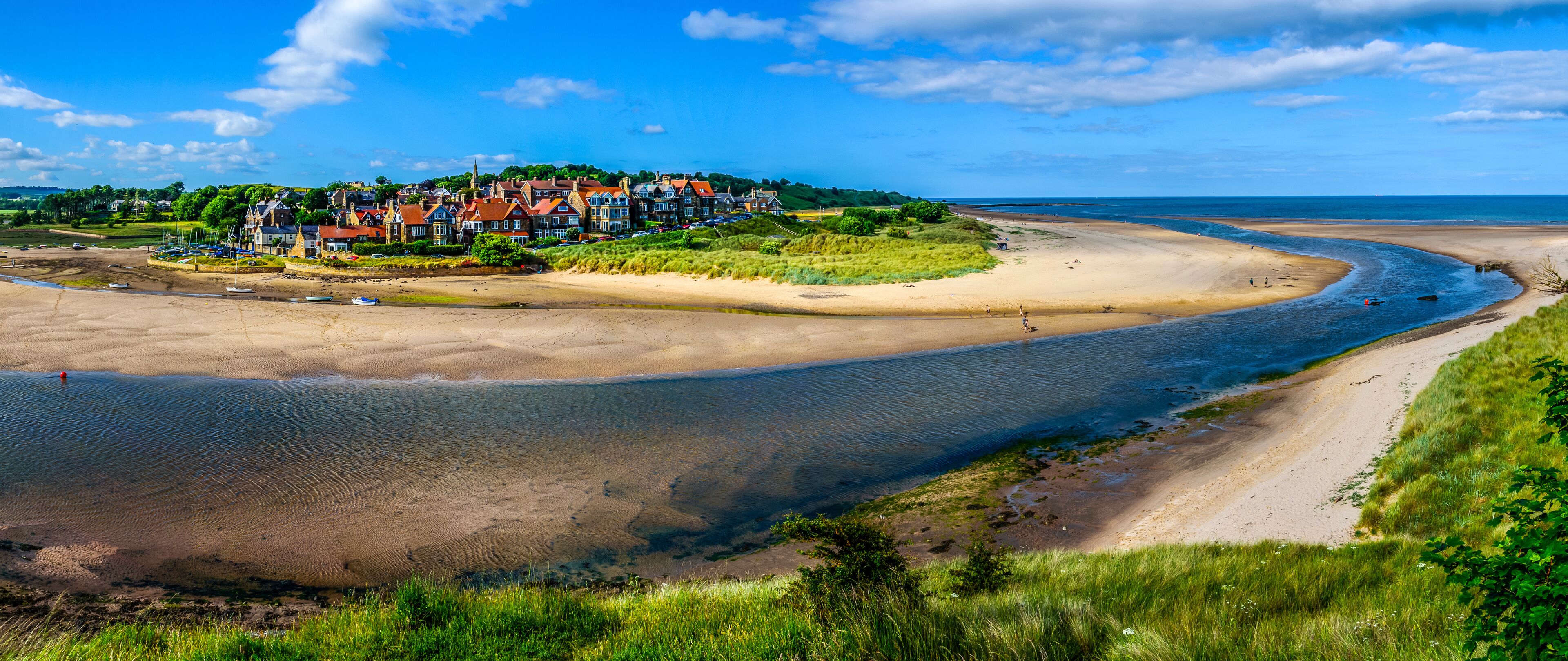 A coastal town with houses, a beach, and a bay.