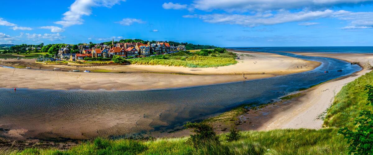 A coastal town with houses, a beach, and a bay.