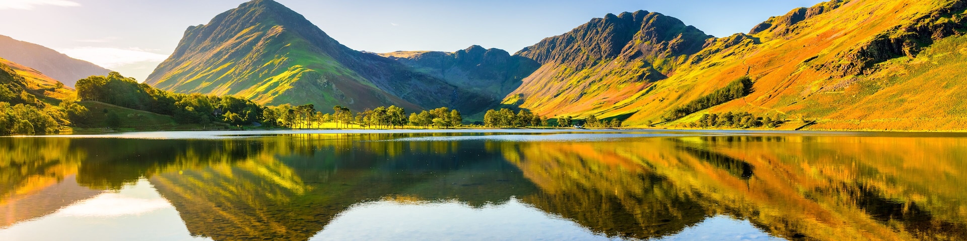 A lake reflecting mountains and trees.
