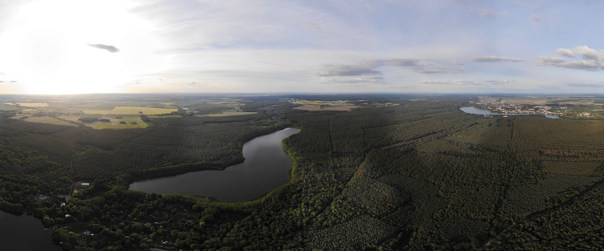 A river winding through a forested valley with a small settlement near the water.