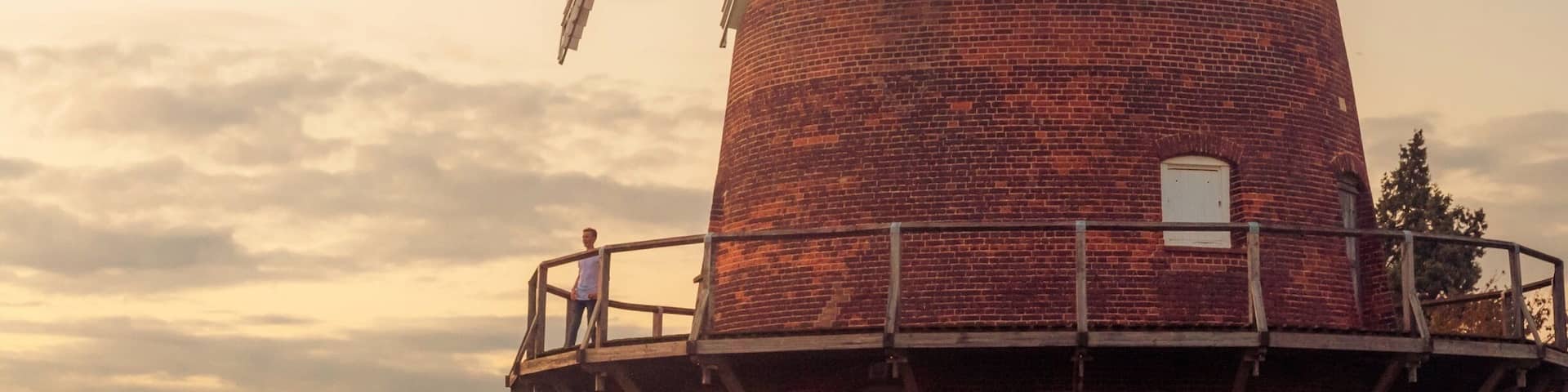 A windmill with large sails and a dome roof.