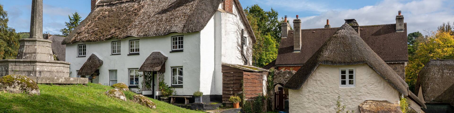 Whitewashed homes surrounding the village green in the pretty Devon village of Lustleigh