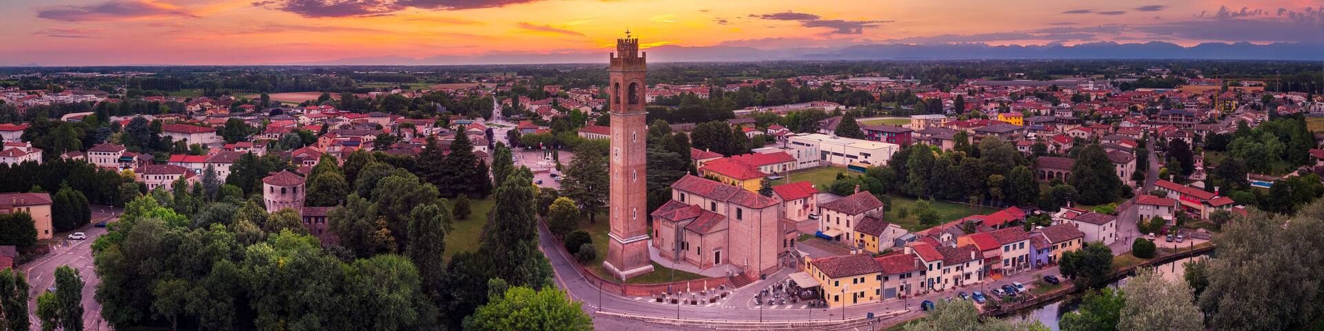 Aerial view of the Casale sul Sile church and harbour on the river Sile at Sunset. On the left the medieval Carraresi Tower.