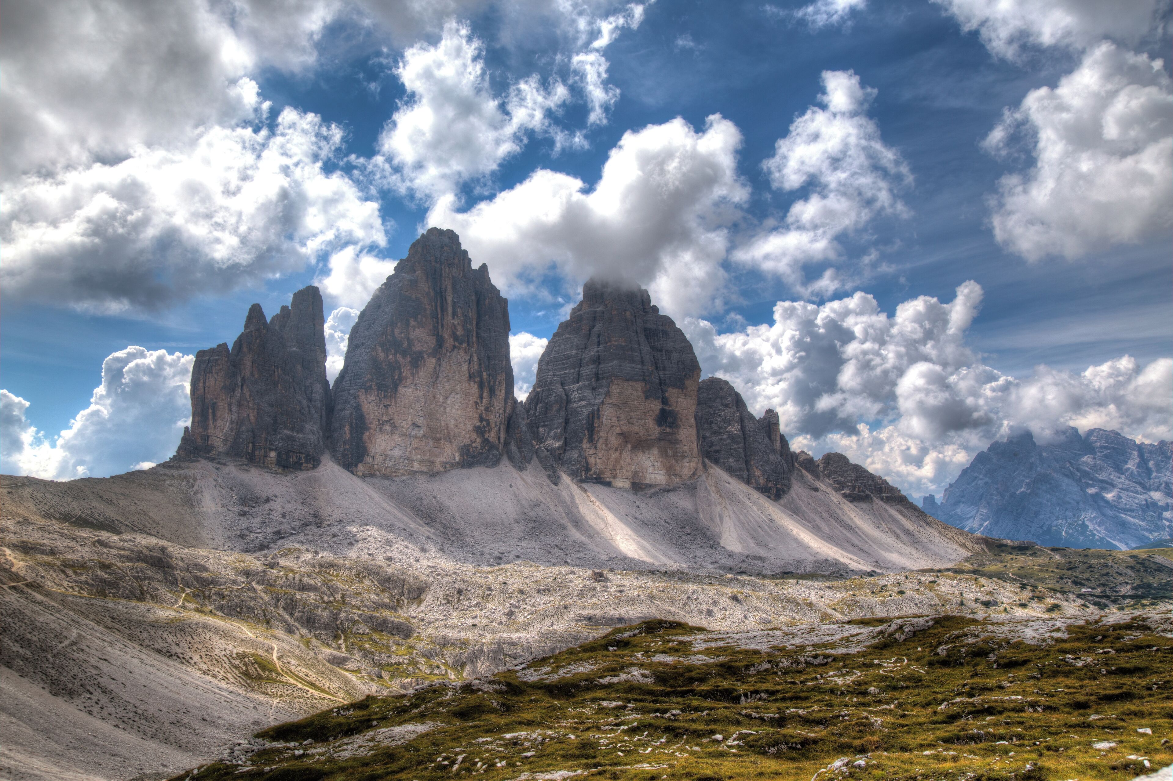 A mountainous landscape with prominent rocky peaks under a partly cloudy sky.