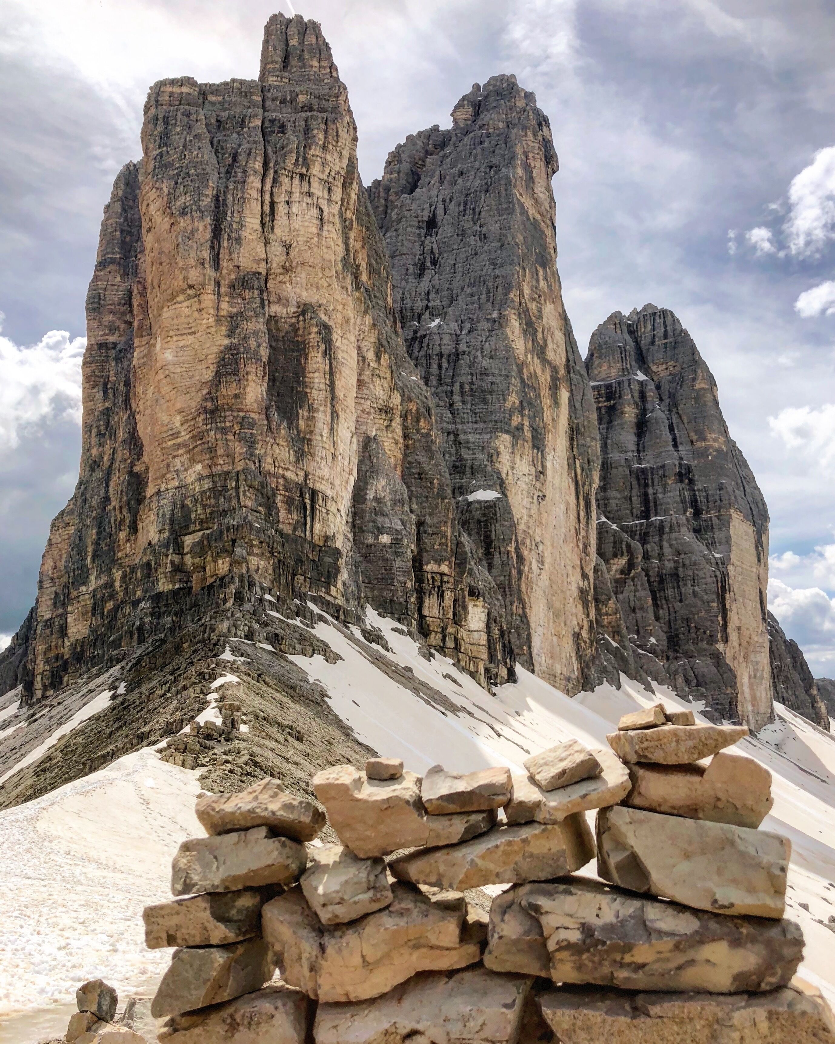 A rocky mountain peak with a stack of stones in the foreground.