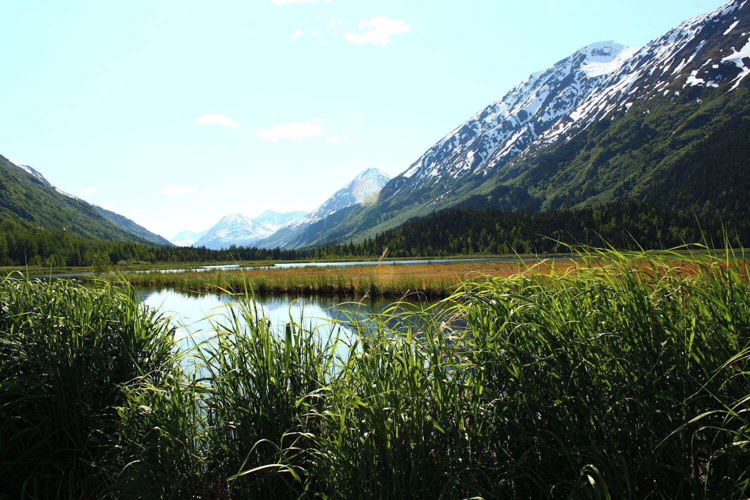 Un lac entouré de montagnes et d’une végétation luxuriante.
