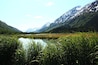 A lake surrounded by mountains and lush greenery.