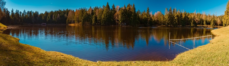 High resolution stitched autumn or indian summer panorama with reflections at Riedelsbach reservoir, Neureichenau, Bavarian forest, Bavaria, Germany