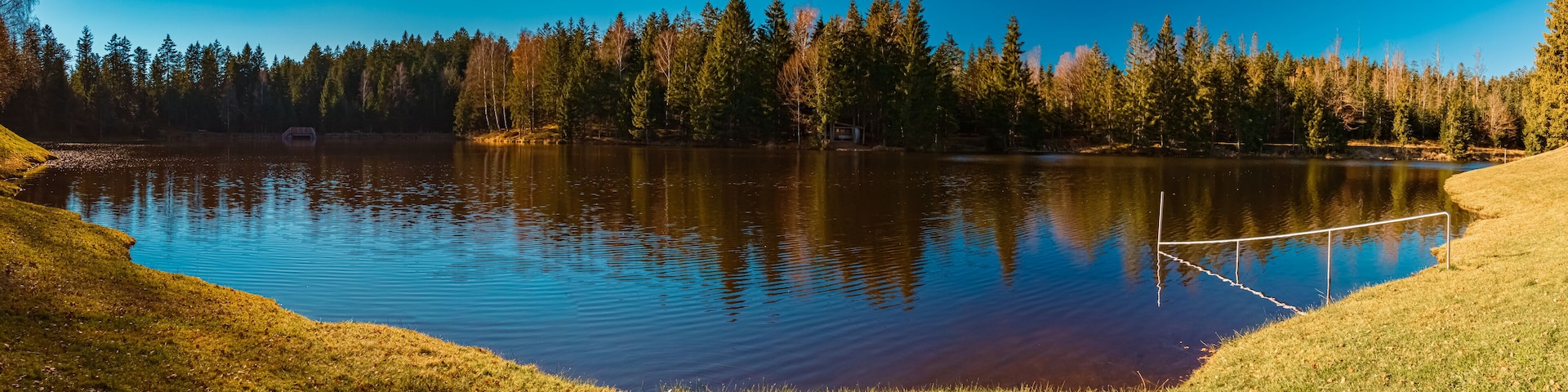 High resolution stitched autumn or indian summer panorama with reflections at Riedelsbach reservoir, Neureichenau, Bavarian forest, Bavaria, Germany