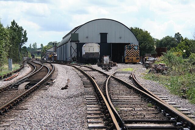 The former Swindon shed at Williton Station on the West Somerset Railway, a steam operated heritage railway in the English county of Somerset. The station platforms can be seen in the left distance. The shed is used by the West Somerset Railway Association for the restoration of locomotives and carriages. Photograph taken with permission using a Lineside Photographic Pass available from the railway at its Minehead station. For more information see the Wikipedia article Williton railway station.