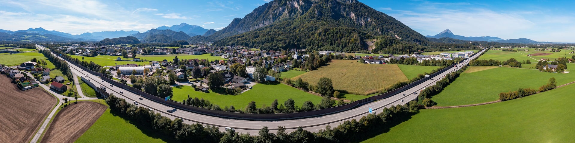 Austria, Salzburger Land, Grodig, Drone panorama of highway stretching past rural town in summer
