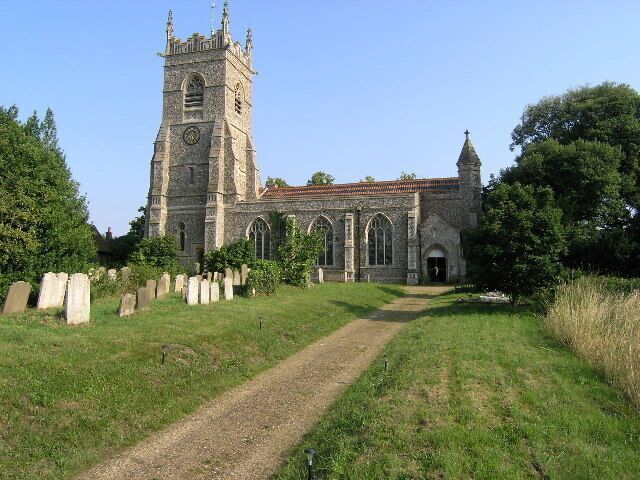 A historic church with a tall tower and arched windows, surrounded by a cemetery.