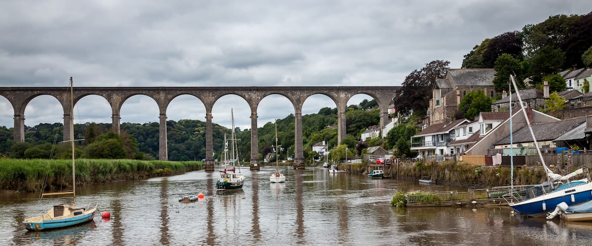 A river with boats, a bridge, and houses along the riverbank.