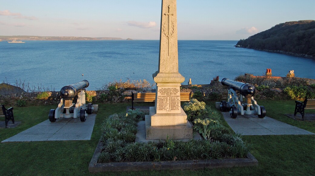 War Memorial in Cawsand, Cornwall. The view is across Plymouth Sound towards Devon. A frigate is entering the sound.