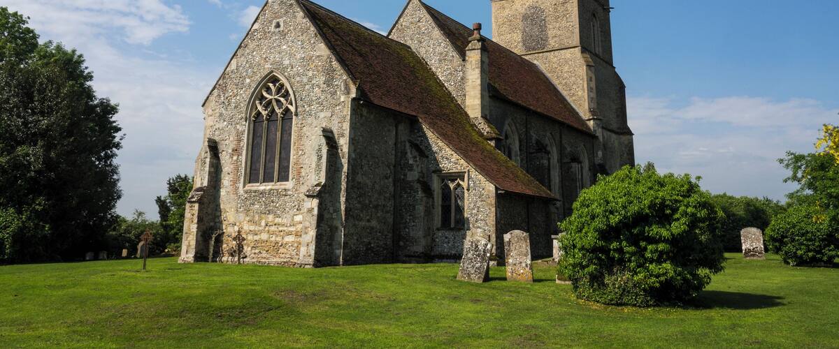 A historic church with a prominent tower and a large arched window.