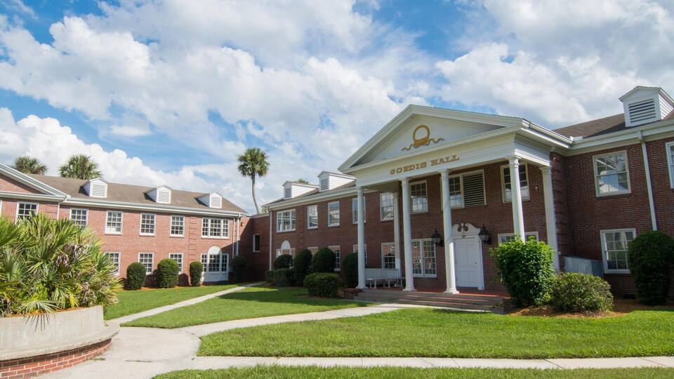 A brick building with a white facade and a sign that reads "CORDIS HALL".
