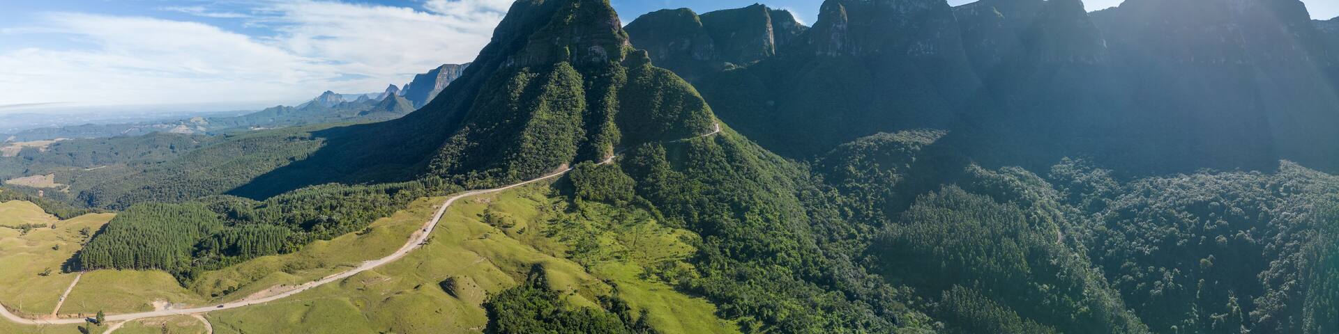 Panorama of the mountains in Brazil. Mountain range in the state of Santa Catarina, place named Serra do Corvo Branco with curved road leading up through the mountain pass