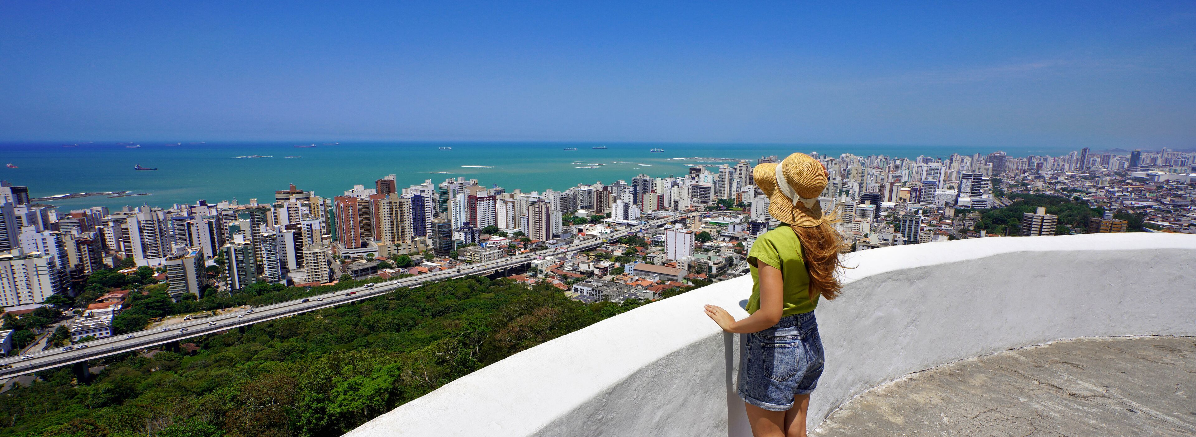 Traveling in Brazil. Panoramic view of female tourist with hat in Vila Velha city, Greater Vitoria, Espirito Santo, Brazil.