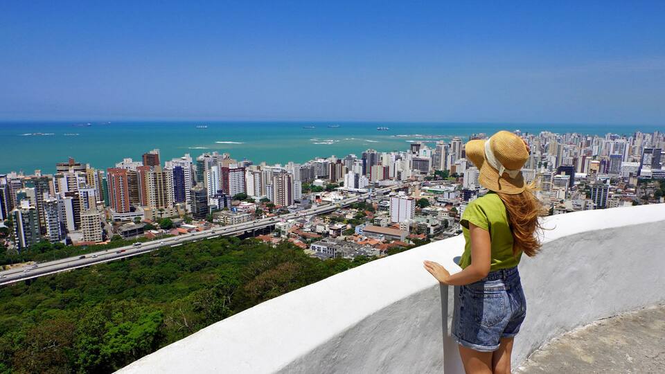 A cityscape with a view of the ocean and a high-rise building.